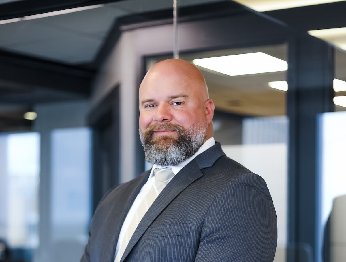 Greg Chansolme standing in front of office glass offices